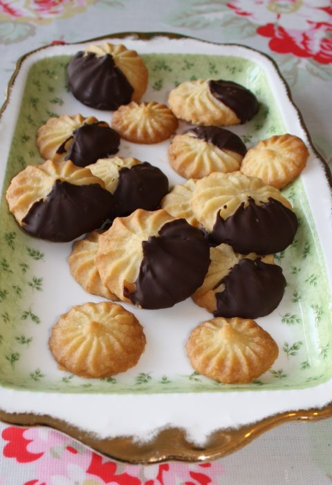 Viennese biscuit dough being piped onto baking sheet