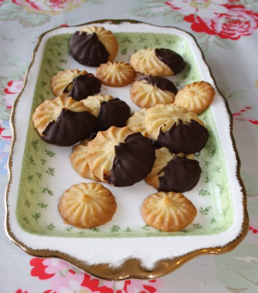 Viennese biscuit dough being piped onto baking sheet