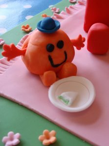 Mr Men and little miss Birthday cake sitting at a picnic