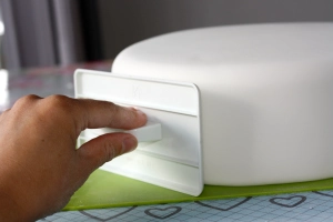 Image: Expertly applying sugarpaste to create a polished cake surface.