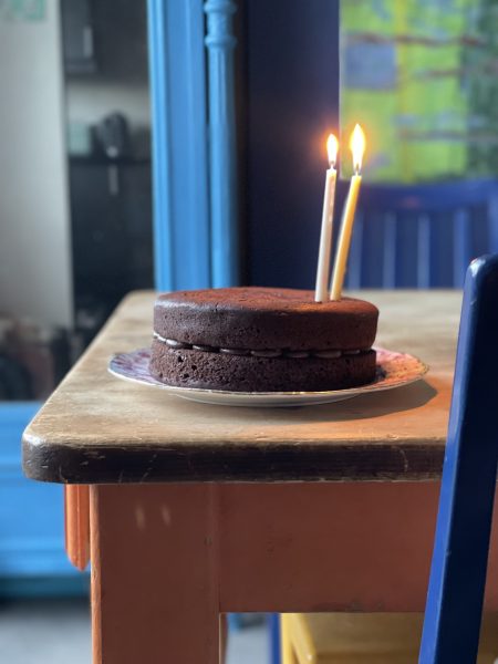 Chocolate cake on kitchen table with two candlesticks inside