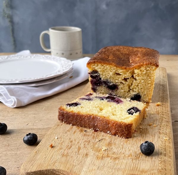 Close-up of a sliced blueberry and lemon loaf cake with a glossy lemon sugar glaze